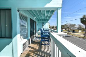 a woman sitting on the porch of a house at Cedar Key Island Condo 228 in Cedar Key