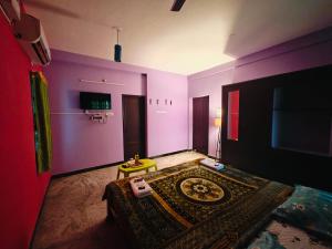 a room with purple walls and a bed with a table at Royal Villa Pondy in Pondicherry