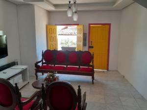 a living room with a red couch and a yellow door at Casa temporada in Lençóis