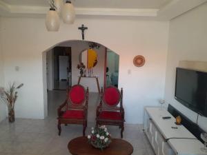 a living room with two chairs and a tv at Casa temporada in Lençóis