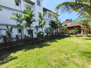 a yard in front of a white building with trees at Rajdeep by Dacha Arambol in Arambol +5 photos
