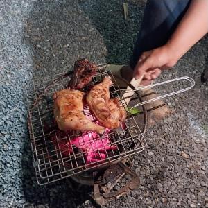 a person is cooking food on a grill at Open Kitchen Chiang Rai in Chiang Rai