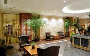 a lobby with chairs and a giraffe on the wall at Harmoni Suites Hotel in Nagoya +41 photos