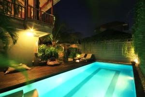 a swimming pool in a backyard at night at Letos Kubu 1 in Kuta