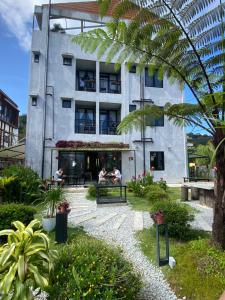 a building with people sitting on a bench in a garden at Silvan Garden Retreat in Tanah Rata