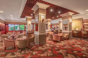 a restaurant with tables and chairs and a bar at Hotel Cambodiana in Phnom Penh +31 photos