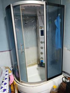 a shower with a glass door in a bathroom at Эламан in Otradnoye