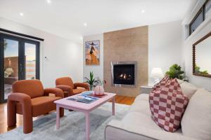 a living room with a couch and chairs and a fireplace at Zen Haven with Sauna & Spa in Tootgarook