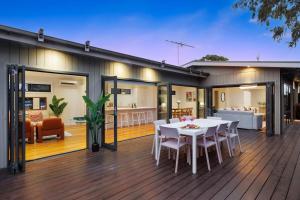 a house with a deck with a table and chairs at Zen Haven with Sauna & Spa in Tootgarook