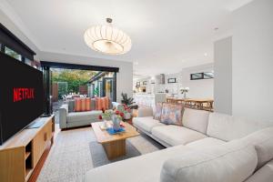 a living room with a couch and a tv at Zen Haven with Sauna & Spa in Tootgarook