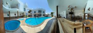 a large swimming pool in the middle of a house at Bungalows Mufrance in San Patricio Melaque