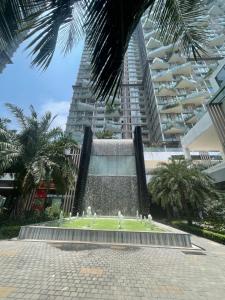 a fountain in front of a large building with palm trees at Canary Nest Solforest Ecopark Homestay in Kim Quan