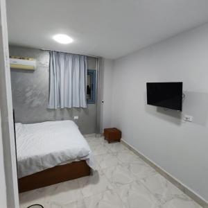 ein Schlafzimmer mit Bett und Flachbildfernseher in der Unterkunft Dell Celio Hotel in Kairo