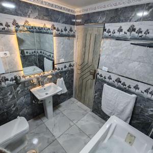ein Badezimmer mit Waschbecken, Toilette und Spiegel in der Unterkunft Dell Celio Hotel in Kairo + 143 Fotos