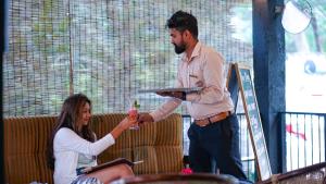 Ein Mann reicht einer Frau einen Teller Essen in der Unterkunft Tea Cottage Resort - Nawalapitiya in Kandy