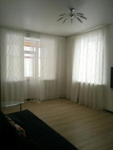 1 dormitorio con ventana y ventilador de techo en Apartment Pavlyukhina 100 en Kazán