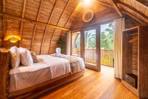 a bedroom with a bed in a wooden house at Misane Serenity in Gianyar +40 photos