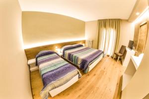 A bed or beds in a room at Grand Hotel Europa Rivisondoli Centro