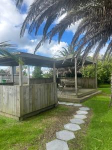 ein Pavillon mit einem Tisch und einer Palme in der Unterkunft The Awanui Hotel in Awanui + 12 Fotos