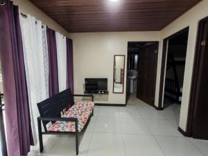 a living room with a couch and a television at Cabinas El Paso de Moisés in Uvita