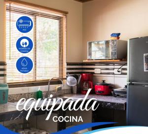 a kitchen with a counter top with a refrigerator at Cabinas El Paso de Moisés in Uvita