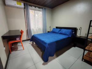 a bedroom with a bed and a desk and a window at Cabinas El Paso de Moisés in Uvita +13 photos