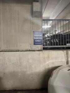a sign that says visitor parking only in a parking garage at The Experience in Houston