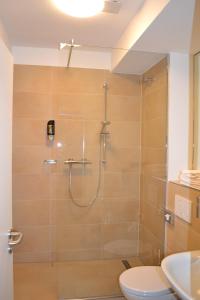ein Bad mit einer Dusche, einem WC und einem Waschbecken in der Unterkunft M&A Cityapartments Hildesheim in Hildesheim