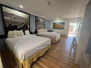 a hotel room with two beds and a painting on the wall at INN at King City in King City +37 photos
