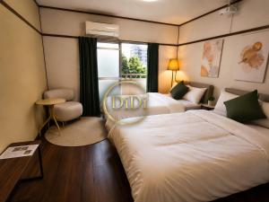 a hotel room with two beds and a window at 徳島駅徒歩10分 公園前 Netflix DiDi Base 203 in Tokushima