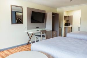 a hotel room with two beds and a desk with a television at INN at King City in King City