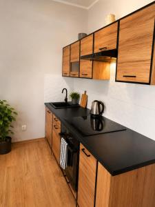 a kitchen with a black counter top and wooden cabinets at DalkoskaStreet in Gniezno
