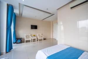 a bedroom with a bed and two chairs and a tv at Khách sạn SIC Quảng Bình in Dong Hoi
