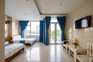 a hotel room with two beds and a flat screen tv at Khách sạn SIC Quảng Bình in Dong Hoi