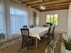 a dining room with a white table and chairs at Gulazyk guest house in Bokonbayevo +46 photos