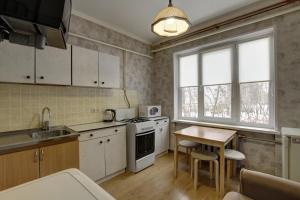 シチョルコヴォにあるЩёлковские квартиры - Циолковского 7の白いキャビネットと木製テーブル付きのキッチン