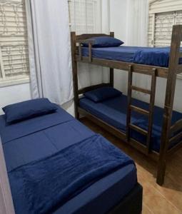 a room with two bunk beds and a window at Pousada Peruibe Praia Centro in Peruíbe