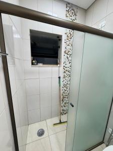 a shower with a glass door in a bathroom at Pousada Peruibe Praia Centro in Peruíbe