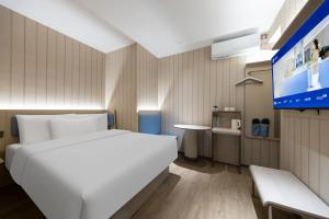 a bedroom with a white bed and a tv at Hanting Hotel Beijing Xizhimen in Beijing