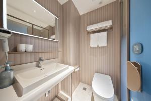 a bathroom with a sink and a toilet and a mirror at Hanting Hotel Beijing Xizhimen in Beijing +25 photos