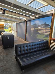 a black leather couch sitting in front of a screen at Kingston Foreshore Caravan Park in Kingston South East