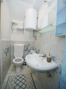 a bathroom with a white toilet and a sink at Apartment Krianca in Zadar