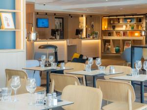 a restaurant with tables and chairs and wine glasses at ibis Loriol Le Pouzin in Le Pouzin