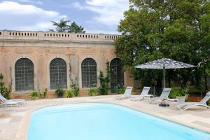 - une piscine avec des chaises longues et un parasol dans l'établissement Château de Briante, à Saint-Lager