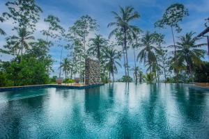 a swimming pool in the middle of a resort with palm trees at Cinnamon View Galle in Galle