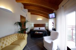 a living room with a couch and a bed and a television at Hotel Coppe Jesolo in Lido di Jesolo
