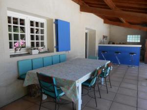 a table and chairs in a kitchen with blue cabinets at Le Relais Du Grand Logis in Civrieux