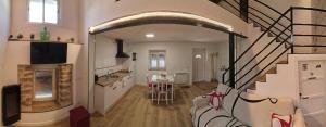 a kitchen and a living room with a spiral staircase at El Nidito del valle del Tietar in La Iglesuela