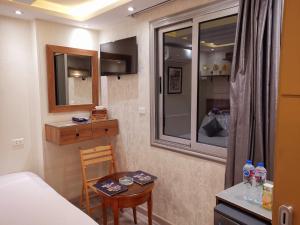 a small room with a bed and a table and a window at tourist hotel cairo downtown in Cairo +282 photos