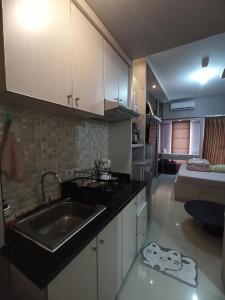 una cucina con lavello e piano di lavoro di Bima Hotel a Surabaya Altre 5 foto